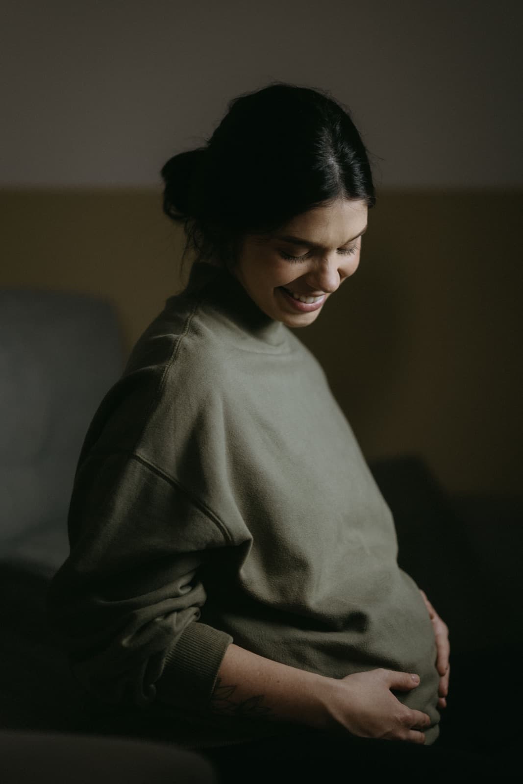 Gestante sorrindo enquanto acaricia a barriga