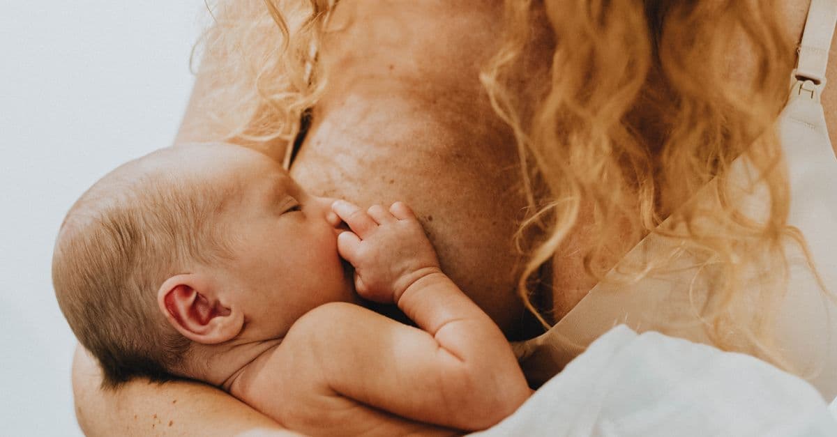 Bebê mamando no colo da mãe