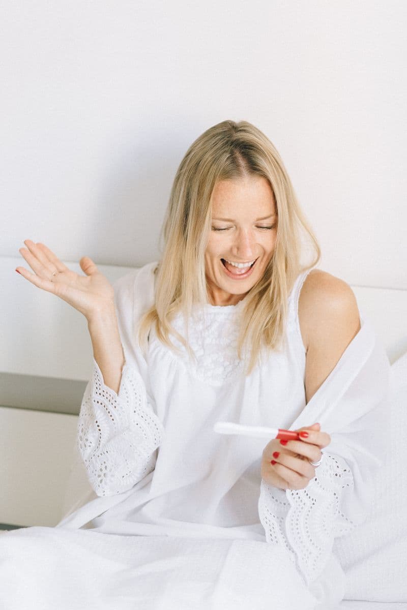 Mulher feliz olhando um teste de gravidez
