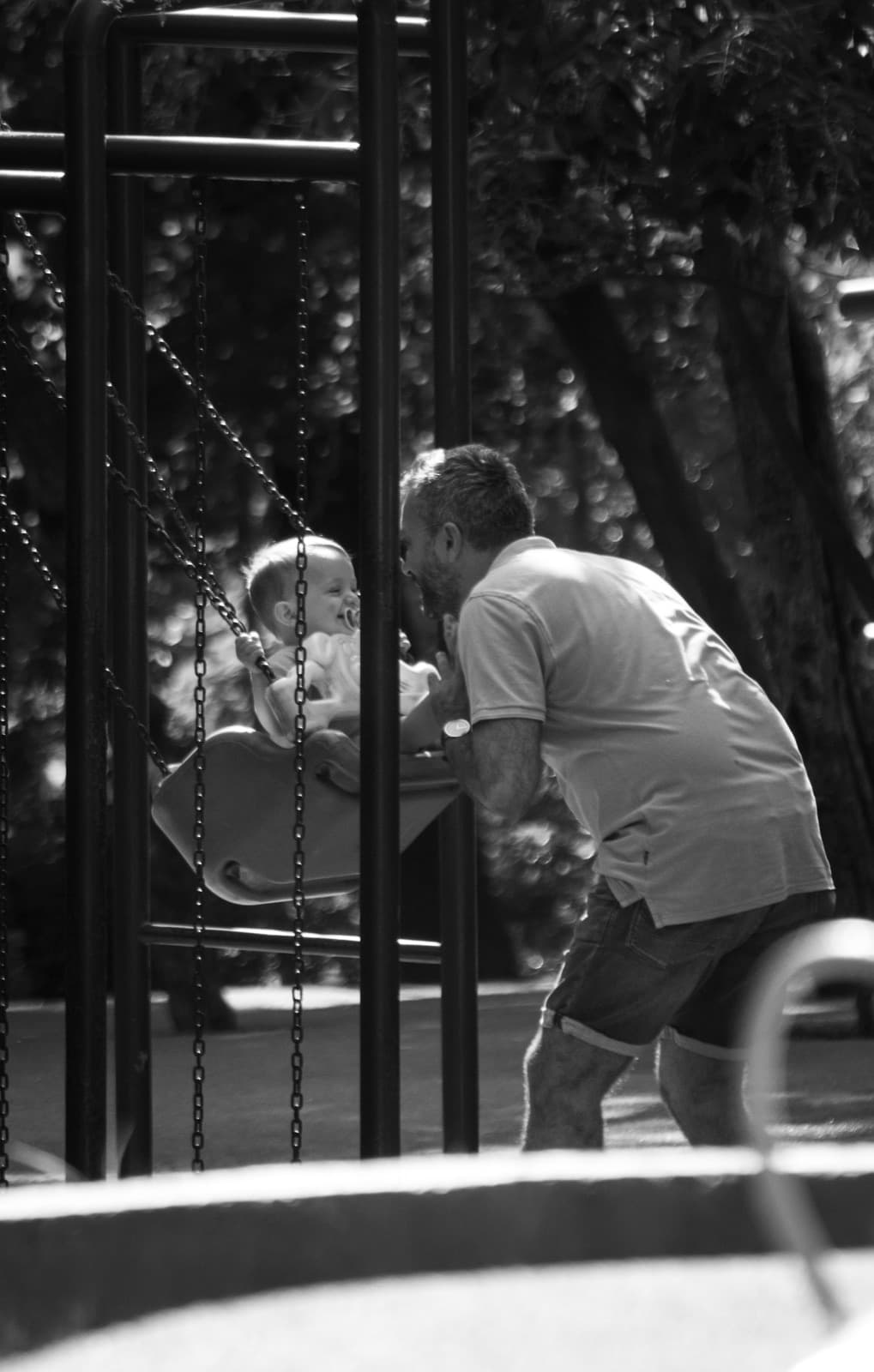 Pai brincando com o bebê no parque